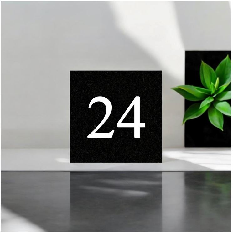 A black square House Sign with clear deep cut numbers featuring a green plant placed elegantly on its surface www.HouseSign.co.uk