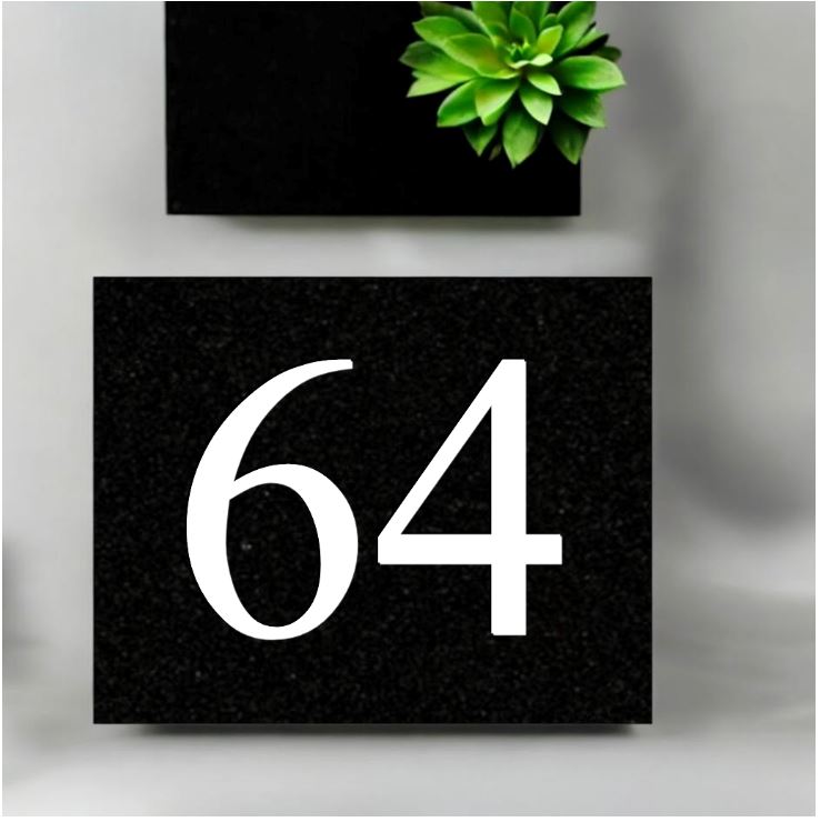 A black square House Sign with clear deep cut numbers featuring a green plant placed elegantly on its surface www.HouseSign.co.uk 