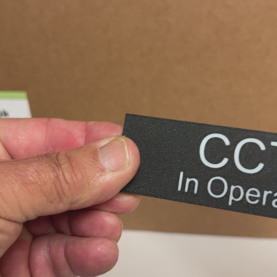 A video showing a CCTV In Operation sign black sign with white lettering.