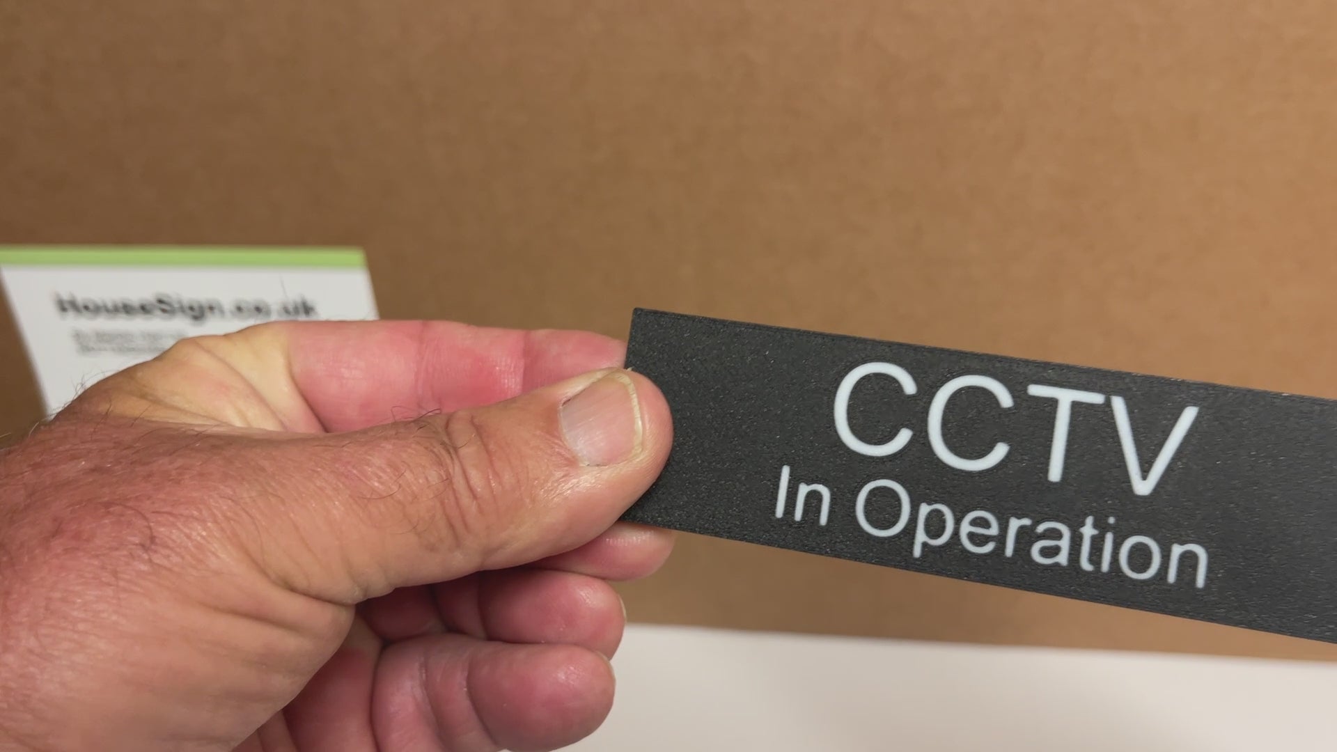 A video showing a CCTV In Operation sign black sign with white lettering.