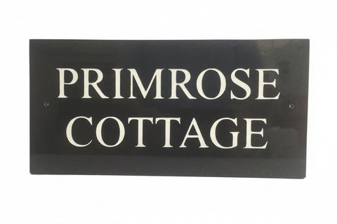 A black square House Sign with clear deep-cut numbers featuring a green plant placed elegantly on its surface www.HouseSign.co.uk 