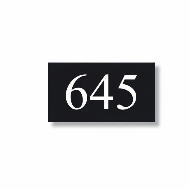 A black square House Sign with clear deep cut numbers featuring a green plant placed elegantly on its surface www.HouseSign.co.uk 