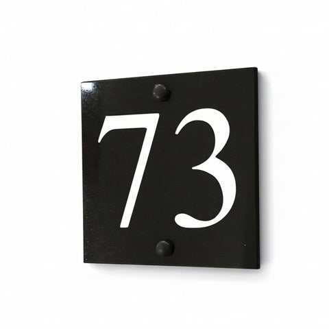 A black square House Sign with clear deep-cut numbers featuring a green plant placed elegantly on its surface www.HouseSign.co.uk 