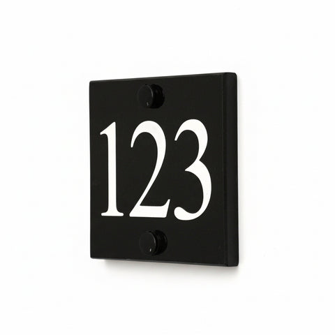 A black square House Sign with clear to see deep cut numbers featuring a green plant placed elegantly on its surface www.HouseSign.co.uk 